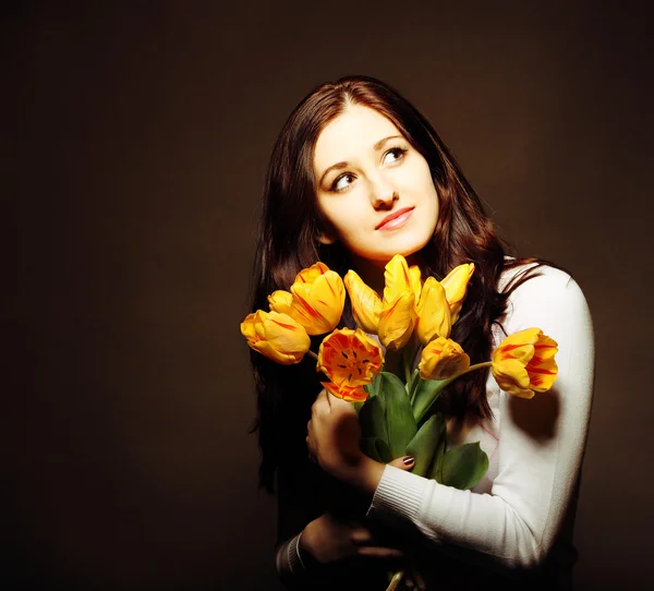 Glückliche brünette Frau mit Tulpen — Stockfoto