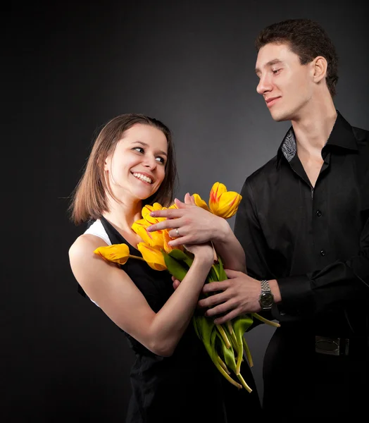 Portrait of a young funny couple in love with flowers — Stock Photo, Image
