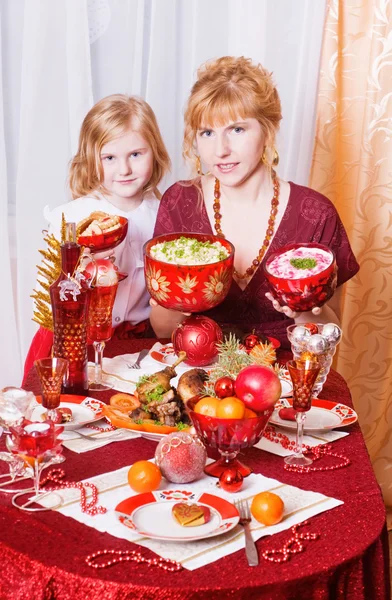Anya a lányát egy karácsonyi asztal — Stock Fotó