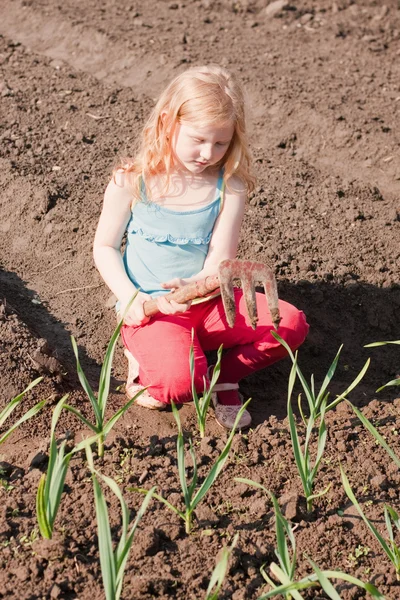 A menina trabalha em um jardim — Fotografia de Stock