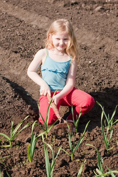 Flickan fungerar i en trädgård — Stockfoto