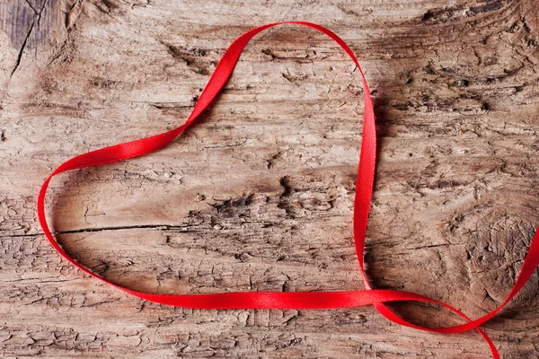Ταινία με τη μορφή της καρδιάς σε ξύλινα φόντο — Φωτογραφία Αρχείου