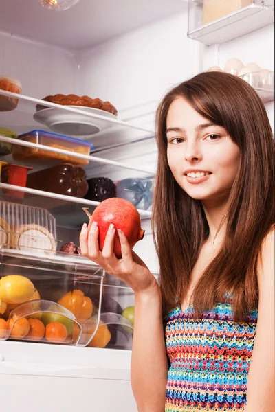 Sorriso menina com romã na cozinha — Fotografia de Stock