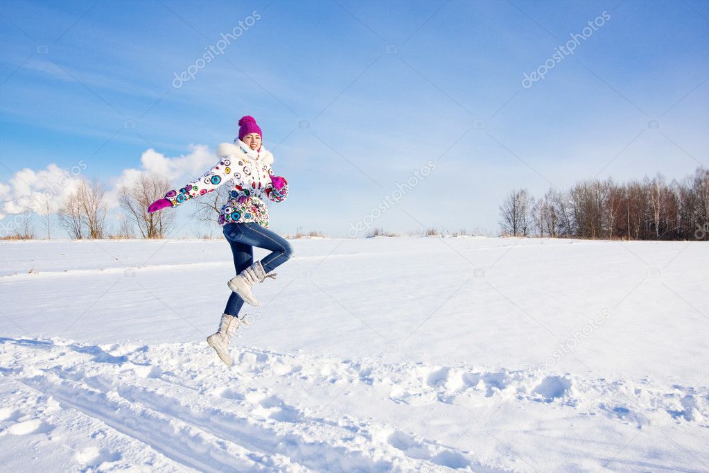 Outdoor winter portrait of beautiful smiling young girl