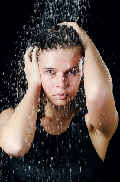 The girl under a shower on the black — Stock Photo, Image