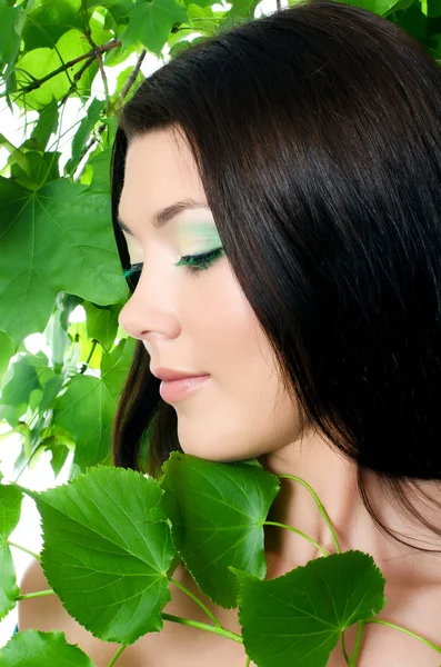 Vacker kvinna med språng grön lämnar — Stockfoto