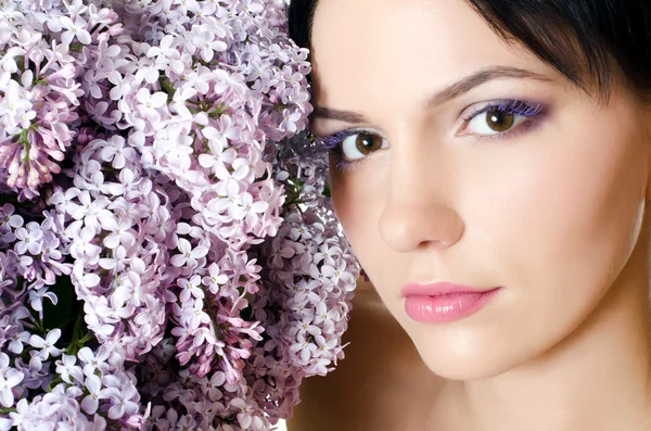 Schöne Frau mit Frühlingsblumen eines Flieders. Hautpflege — Stockfoto