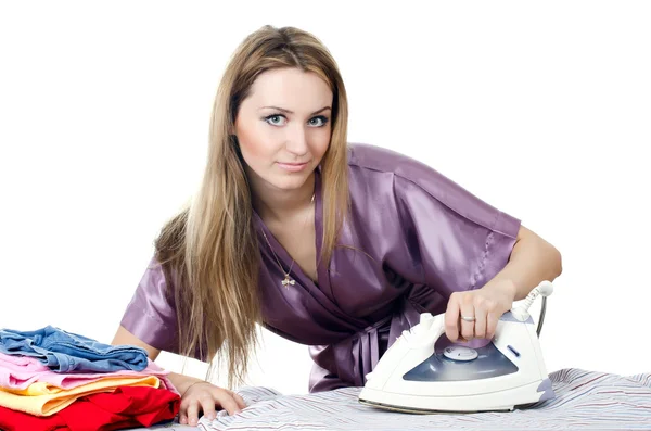 De vrouw de huisvrouw strijkijzers linnen — Stockfoto