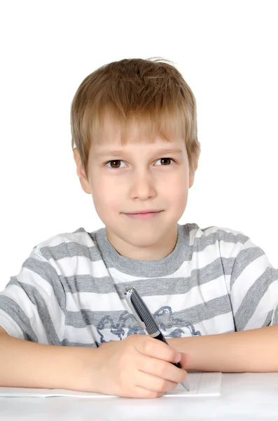 Мальчик пишет книжкам шариковую ручку. — стоковое фото