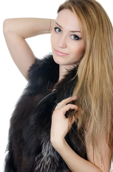 The beautiful girl in a fur vest isolated — Stock Photo, Image