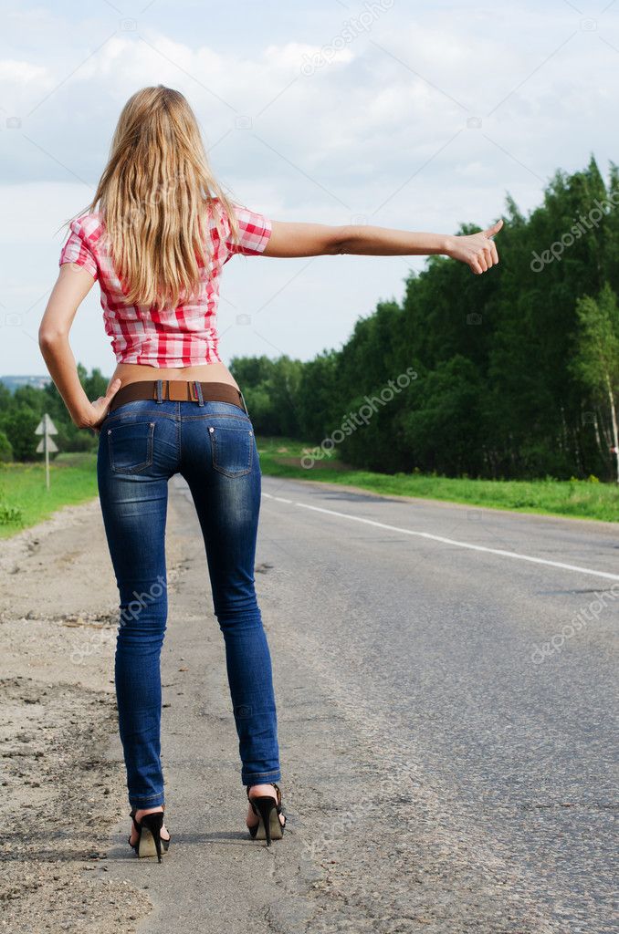 The girl in jeans stops the car on road