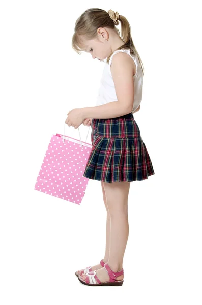 A menina com um pacote rosa isolado — Fotografia de Stock