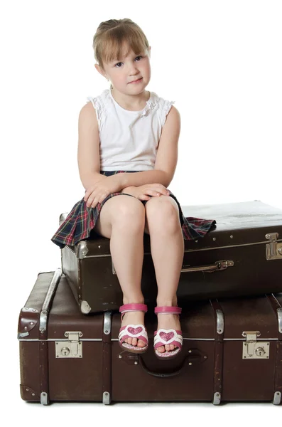 Het kleine meisje op oude koffers — Stockfoto