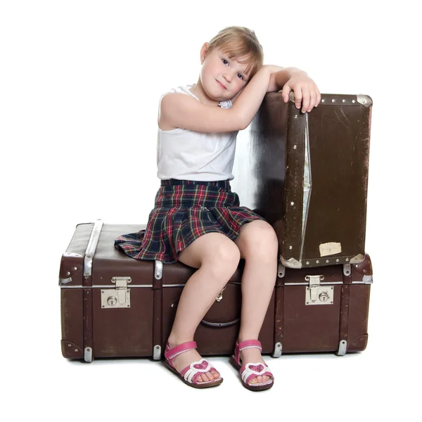 Het kleine meisje op oude koffers — Stockfoto