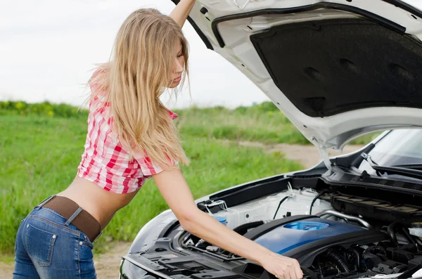 Das schöne Mädchen repariert das Auto — Stockfoto