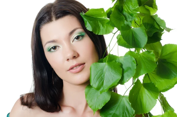 Schöne Frau mit frühlingshaften grünen Blättern — Stockfoto