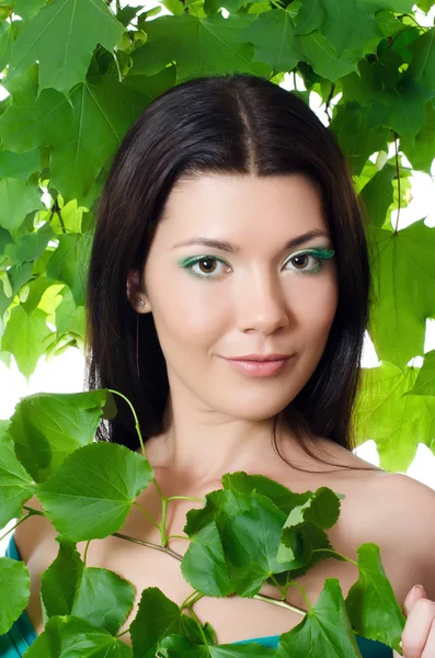 Schöne Frau mit frühlingshaften grünen Blättern — Stockfoto