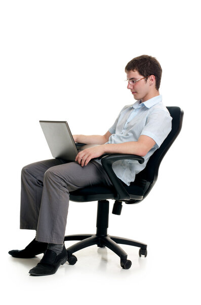 The businessman sits in armchair with laptop