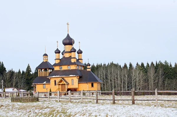 Wooden church against winter wood — 图库照片