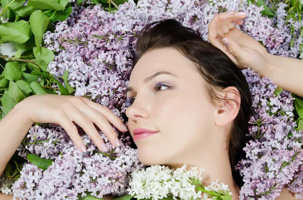 Szép nő, a tavaszi virágok a lila. Bőrápoló — Stock Fotó