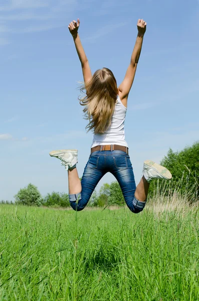 Прыгучая девочка против неба — стоковое фото