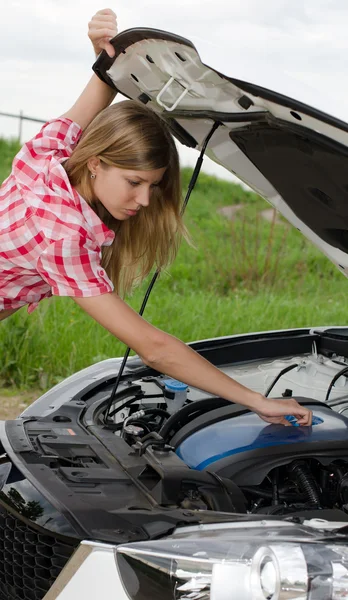 Het mooie meisje reparaties de auto — Stockfoto