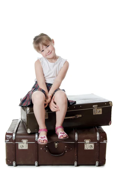 The little girl on old suitcases Stock Picture