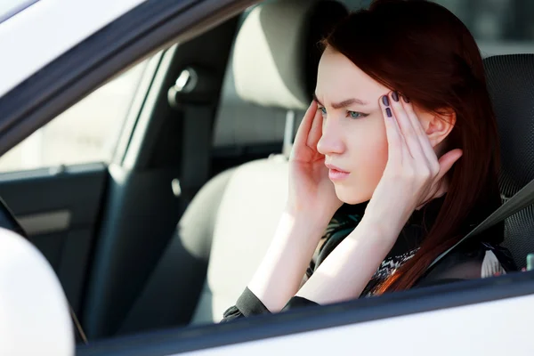 Kvinna med huvudvärk i en bil — Stockfoto