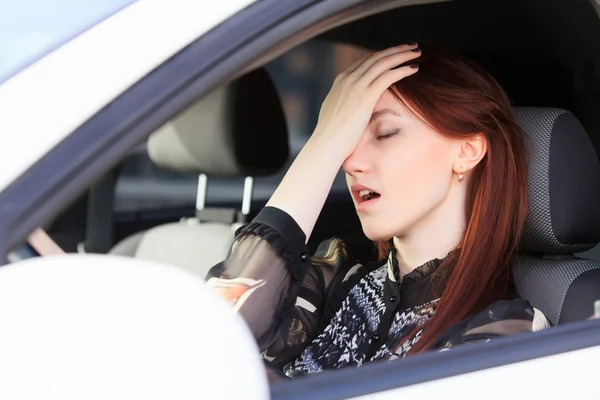 Nainen, jolla on päänsärkyä autossa — kuvapankkivalokuva