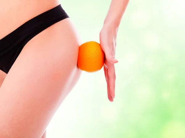 Parte posteriore femminile con uno sfondo arancione, verde sfocato — Foto Stock
