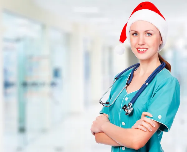 Kırmızı Noel Baba şapkası giyen doktor gülümseyen