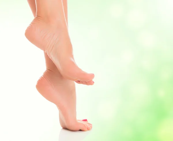 Female feet on blurred green background — Stock Photo, Image