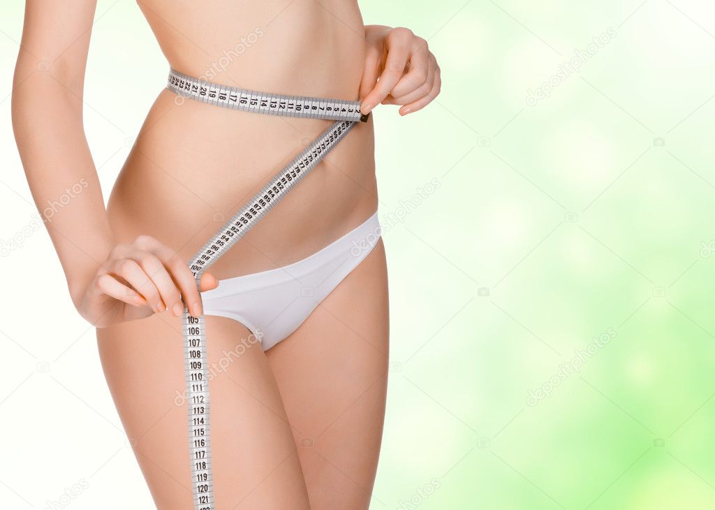 Girl taking measurements of her body, green blurred background