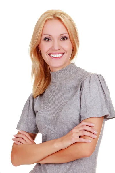 Donna sorridente in piedi con le braccia incrociate contro un backgrou bianco — Foto Stock