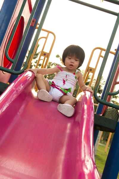 Ребенок на горке на детской площадке — стоковое фото