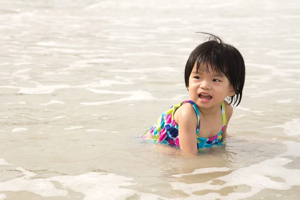 Barn njuta av vågorna på stranden — Stockfoto