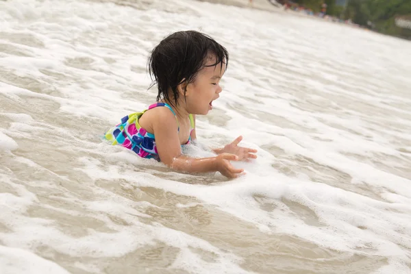 Dítě užívat vlny na pláži — Stock fotografie