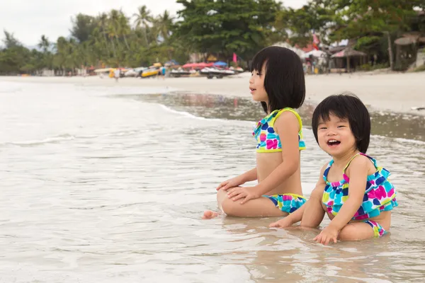 Los niños disfrutan de olas en la playa — Foto de Stock