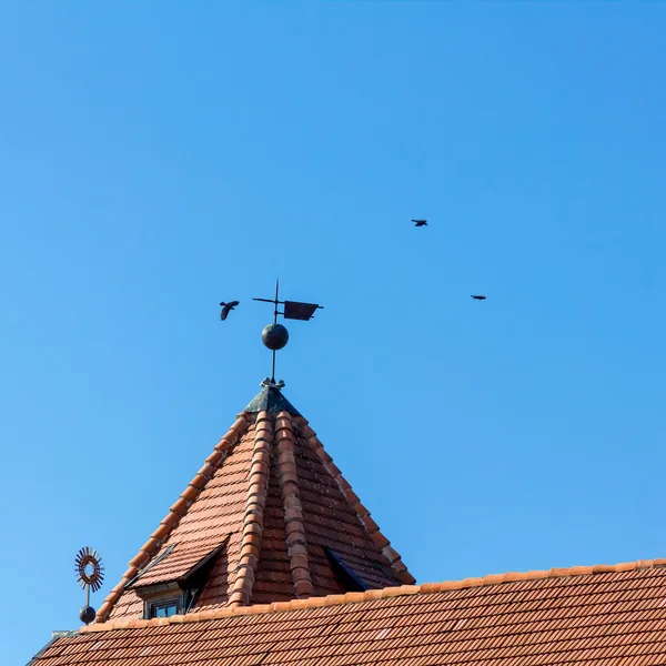 Corbeaux volant au-dessus du toit carrelé du château à Mir, Biélorussie . — Photo