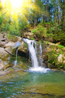 Waterfall on a mountain river in the spring clipart
