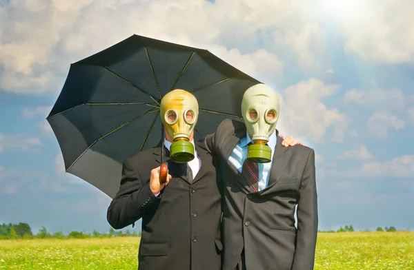 stock image Two men in gas-mask on meadow. Conceptual composition