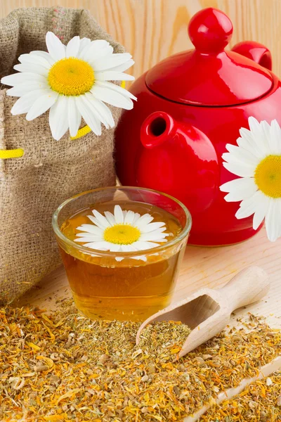 Chá de camomila saudável, bule vermelho e saco com margaridas — Fotografia de Stock