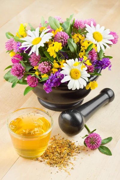 Mortero con hierbas y flores curativas, té de hierbas en la mesa, alte —  Fotos de Stock