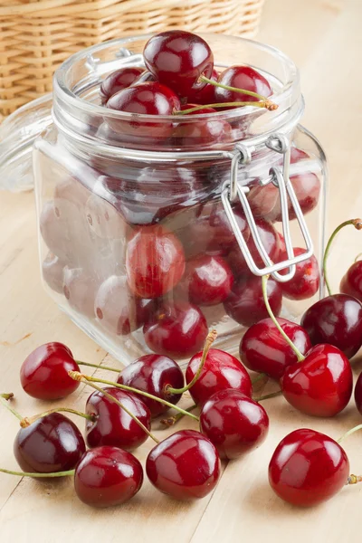 Cherries in glass jar on kitchen table — Stock Photo, Image