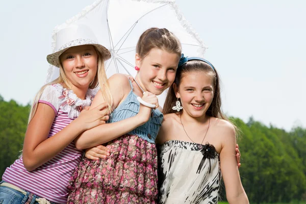 三个快乐年轻女孩朋友在伞下 — 图库照片