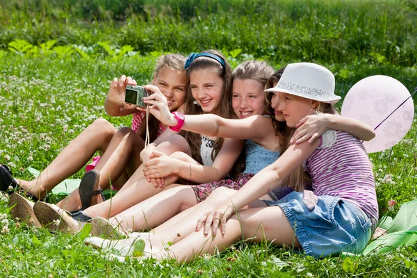 Beautiful girls taking picture on grass in city park outdoors — Stock Photo, Image