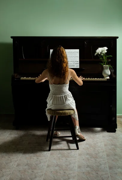 Молодая девушка и фортепиано дома — стоковое фото