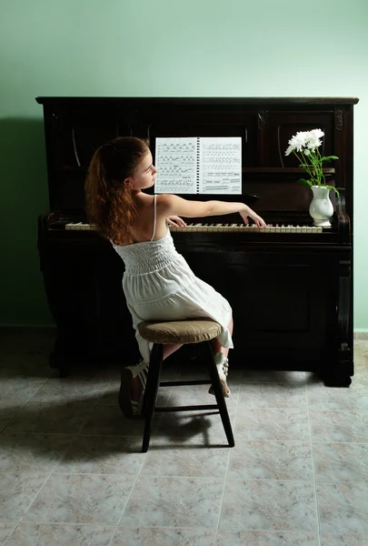 Mladá dívka a klavír doma — Stock fotografie