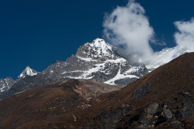 Dağ zirvesi ve Himalayalar bulutlarda