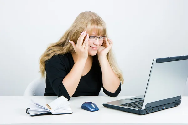 Smiling blonde looks at the monitor — Stock Photo, Image
